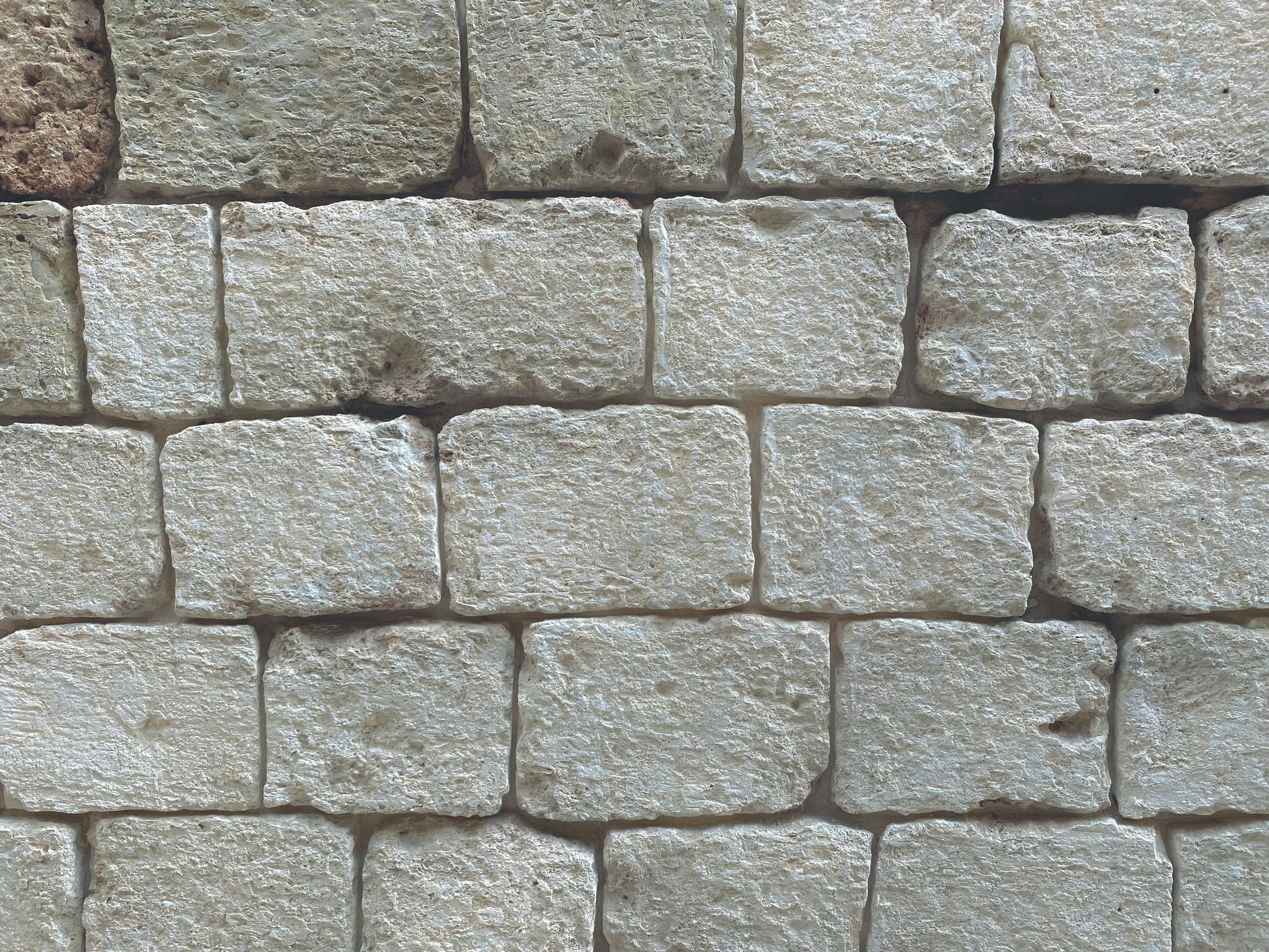 Stone brick wall, grey blocks neatly arranged in rows.