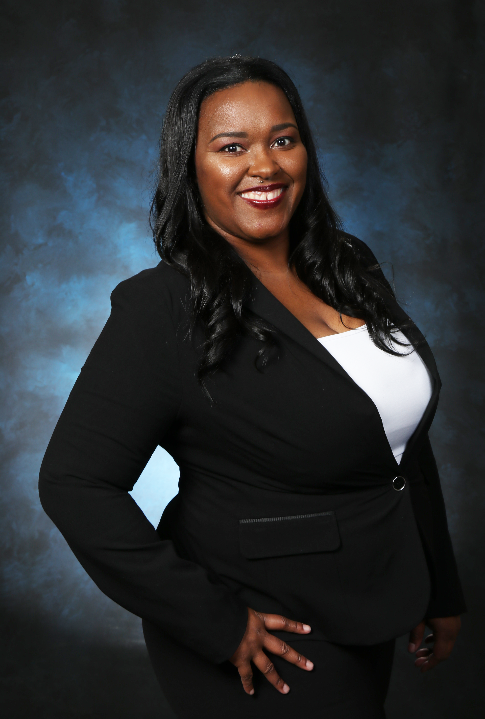 Alissa Hurns in a black jacket and white shirt smiles for the camera