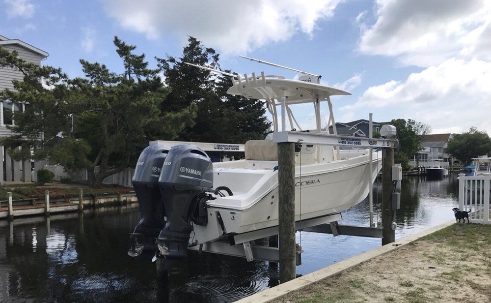 A boat is sitting on a lift in a body of water.
