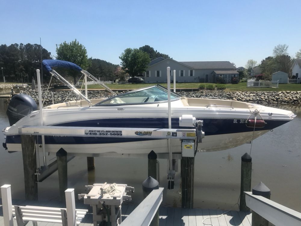 A boat is sitting on a lift in the water