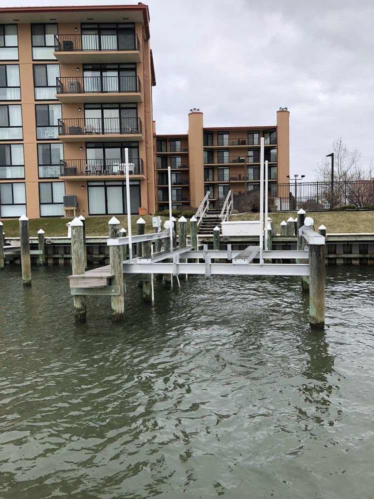 A dock in the water with a building in the background