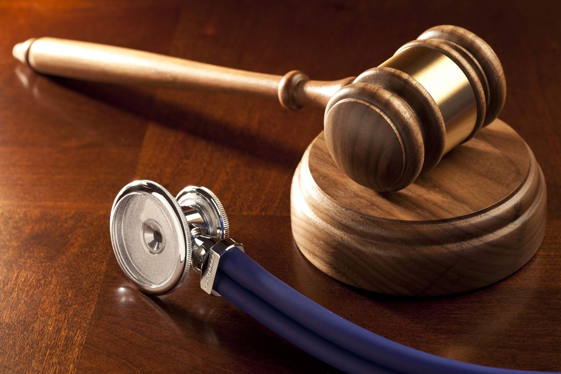 Wooden gavel and stethoscope on table symbolizing healthcare law and medical justice concepts.