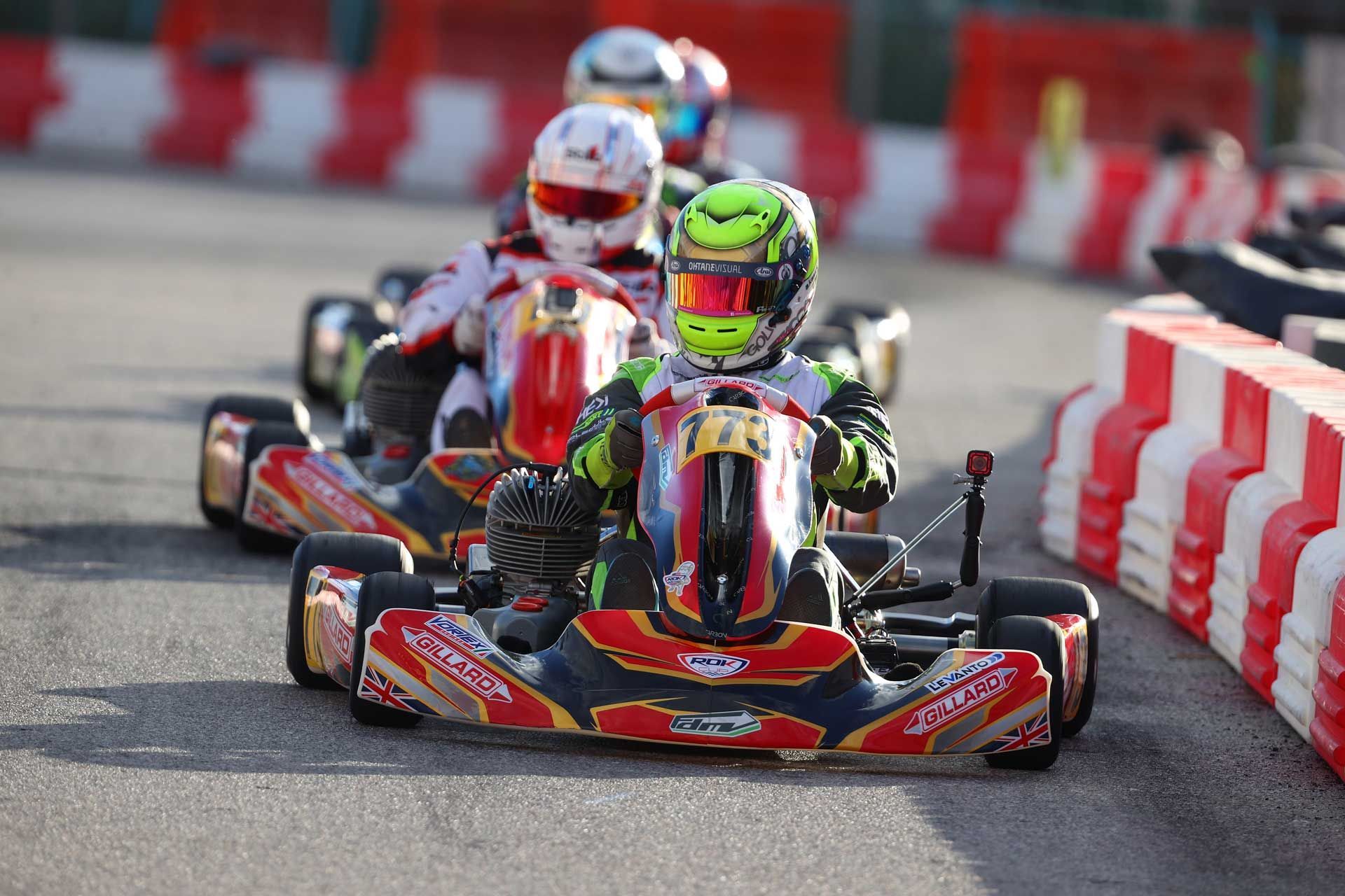 A group of people are riding go karts on a track.