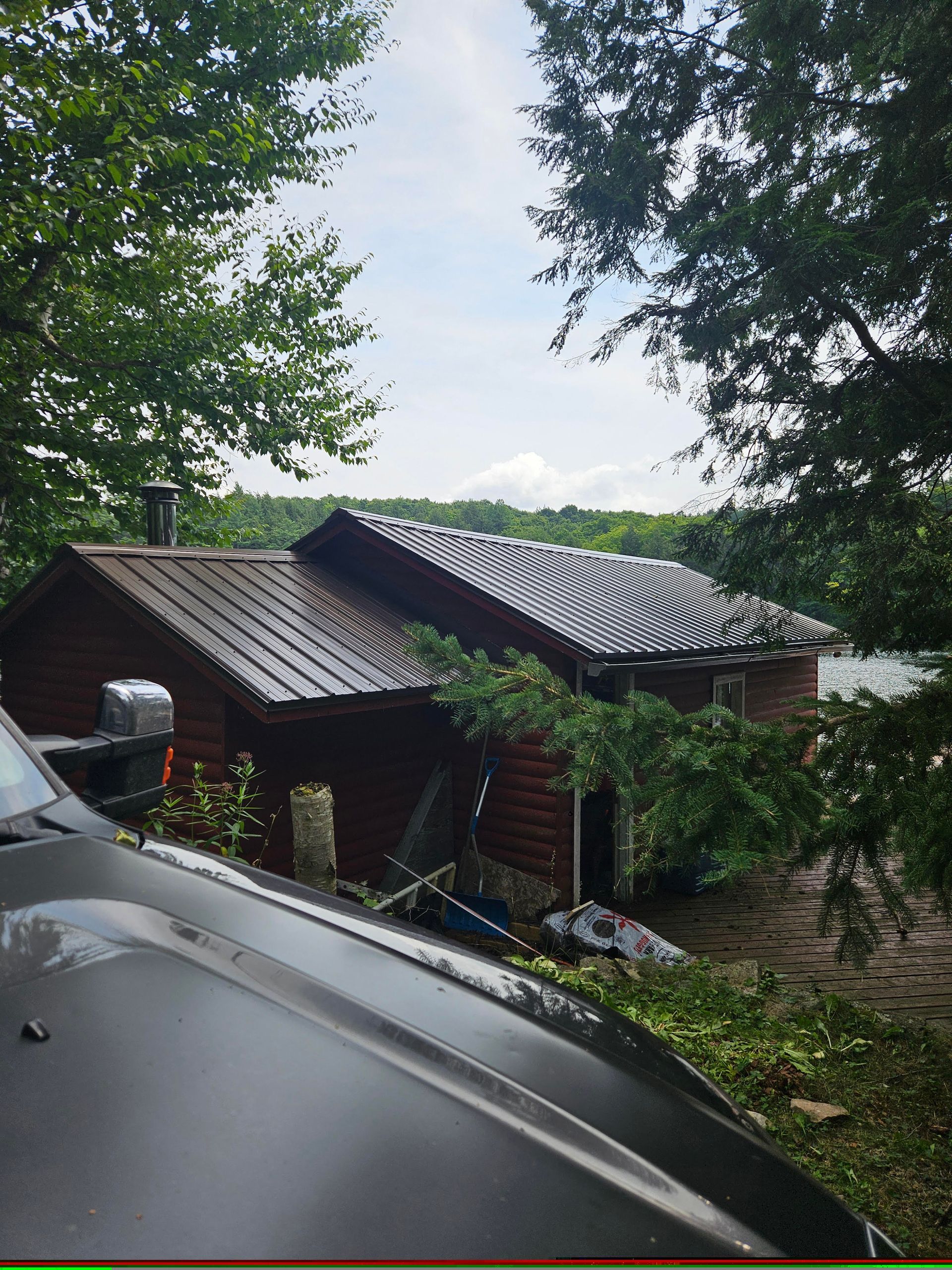 A black truck is parked in front of a log cabin.