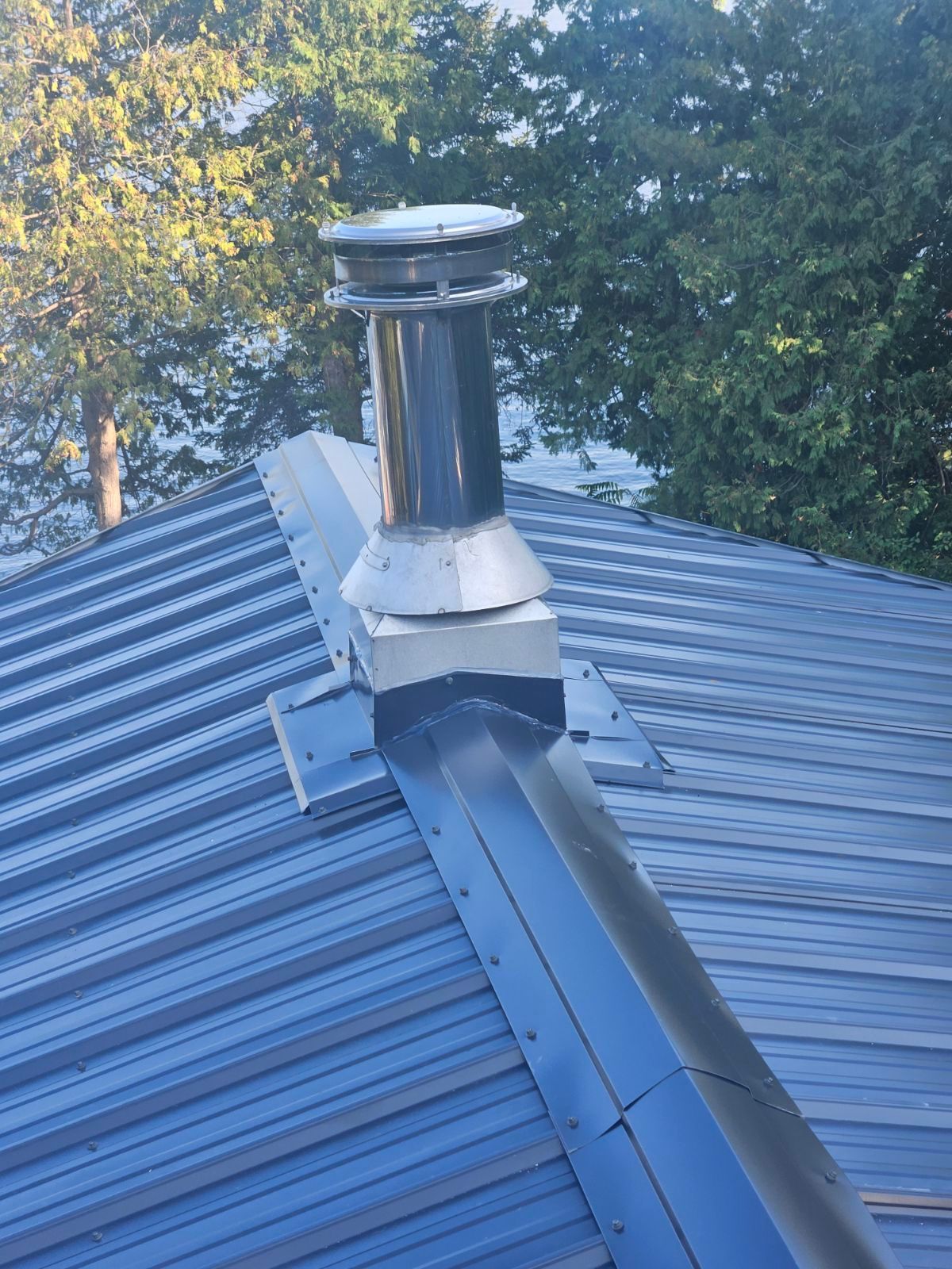 A metal roof with a chimney on top of it.