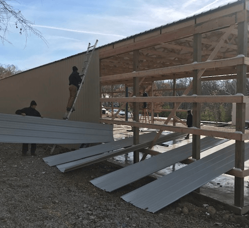Workers laying metal sheets on commercial shop