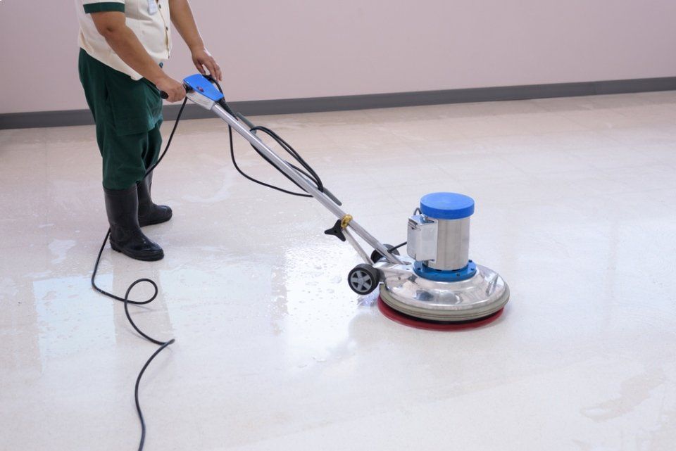 Un uomo sta pulendo il pavimento con una macchina.
