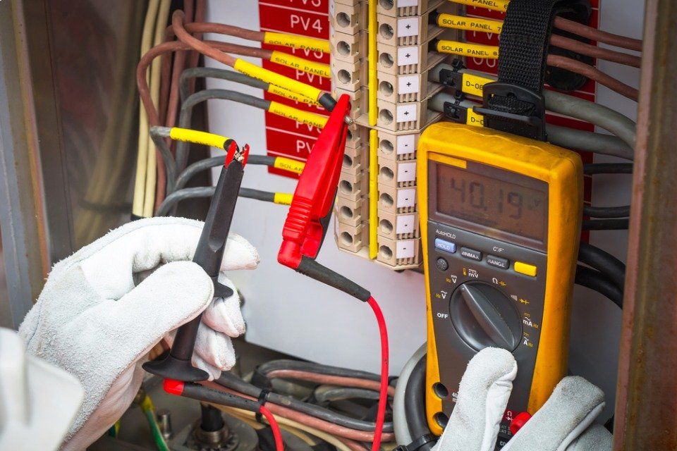 Una persona sta usando un multimetro per testare un circuito stampato.