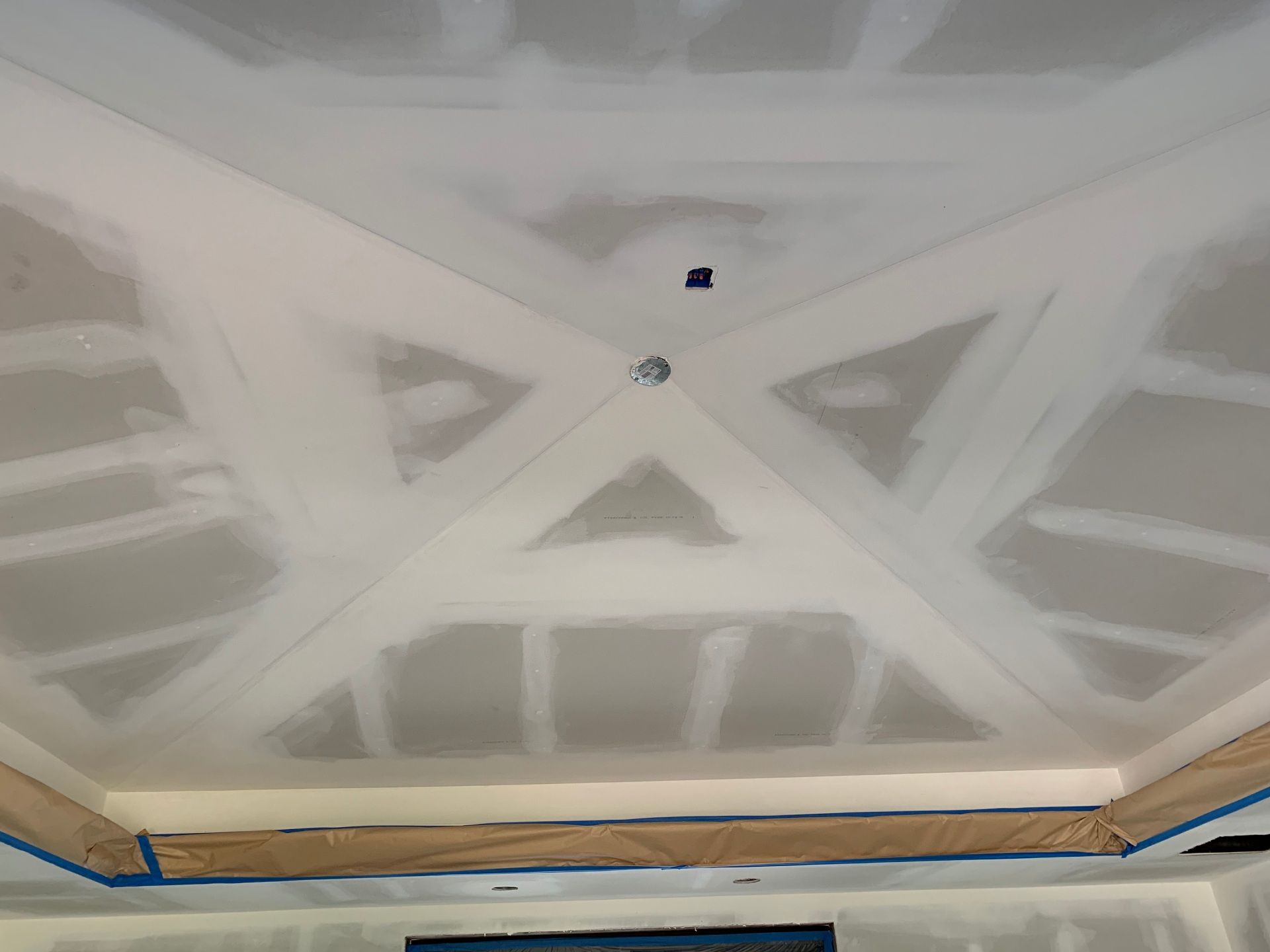 A room with a ceiling that is being painted white