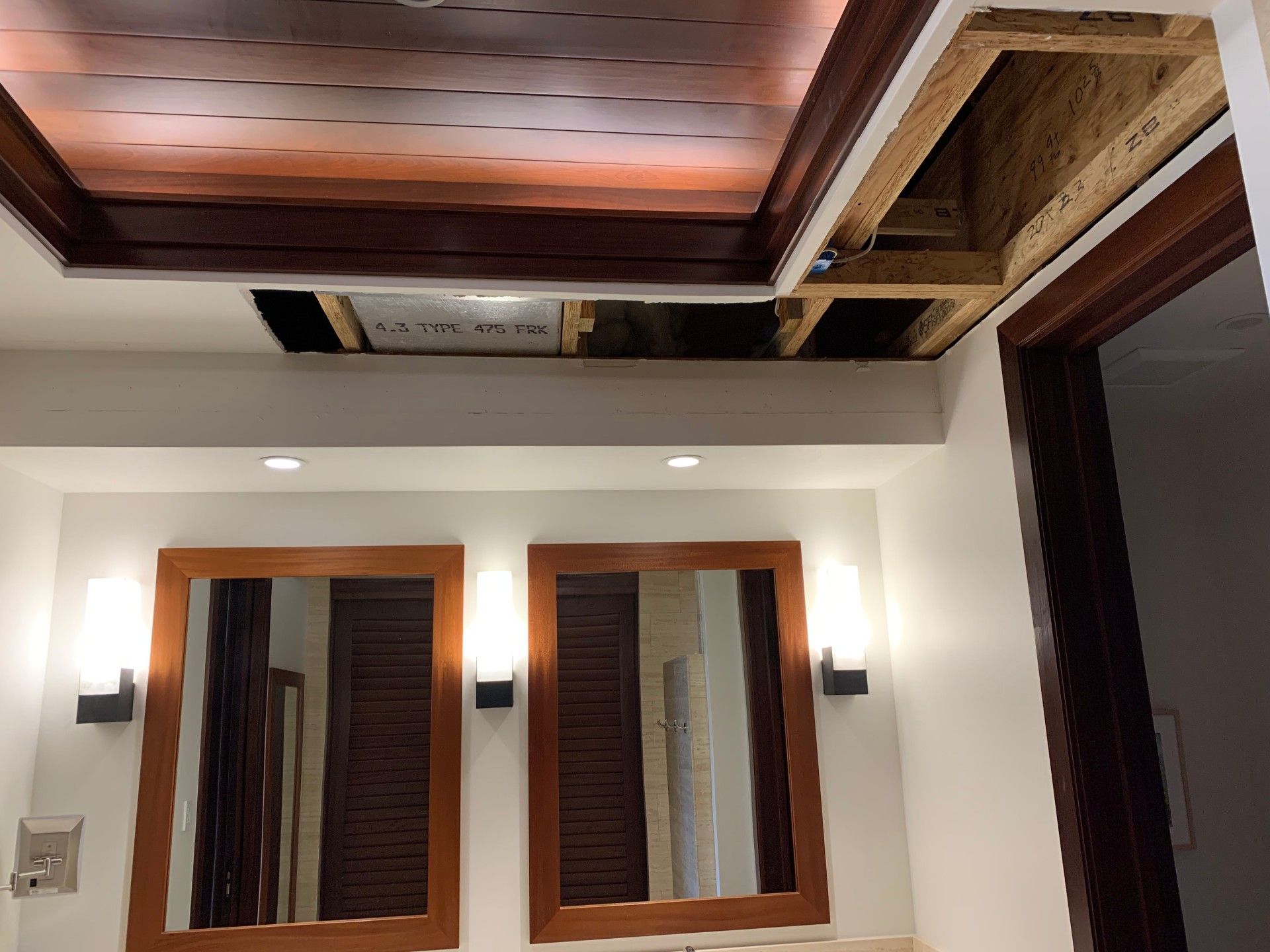 A bathroom with a wooden ceiling and drywall repair.