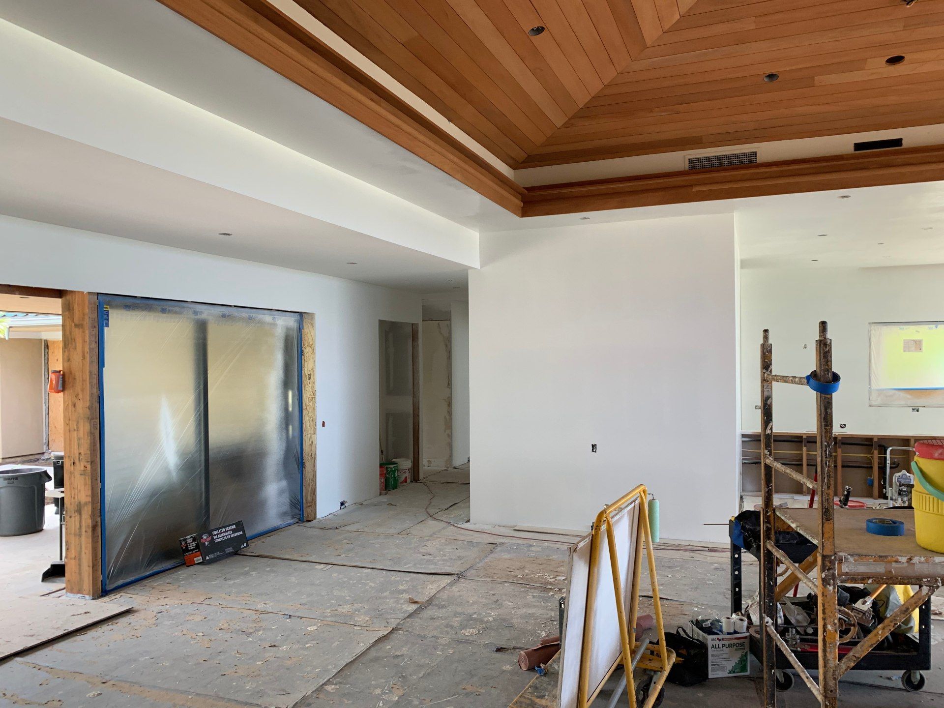 A large room with a wooden ceiling is being remodeled.