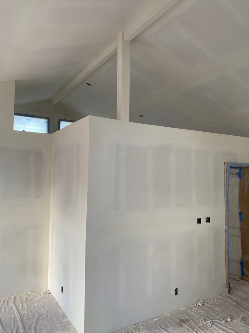 A room with white walls and a ceiling that is being painted.