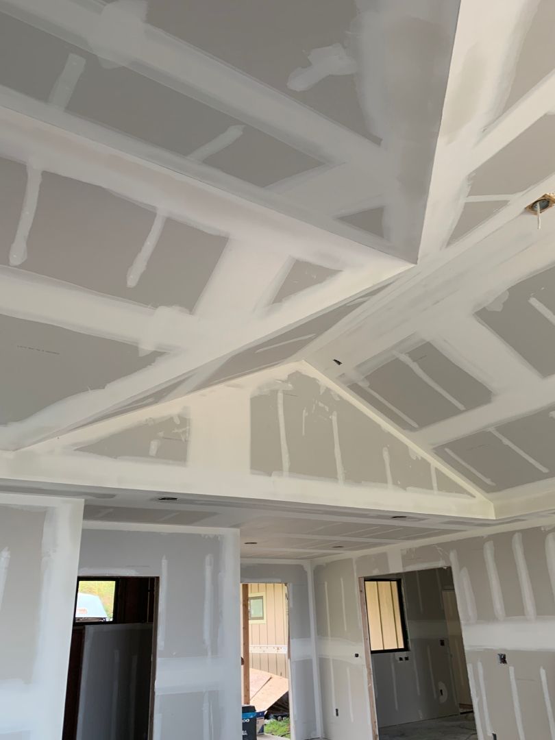 A room with a vaulted ceiling using drywall is being remodeled