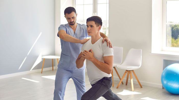 A man at a Physical Therapy clinic doing exercises.