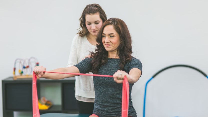A woman at a clinic doing work conditioning exercises.