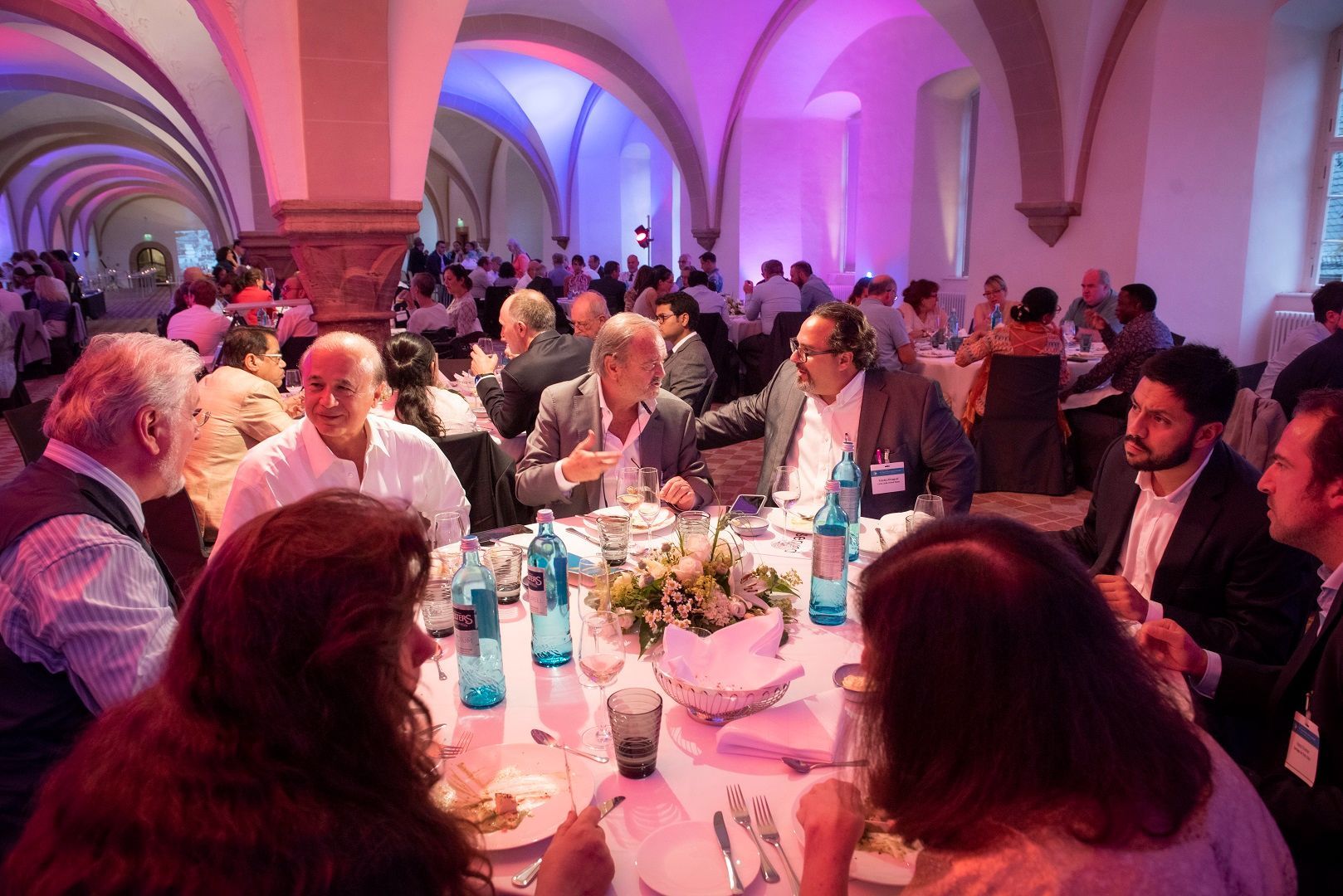 Menschen an Tischen beim Social Evening des Theranostics World Congress 2022 in Wiesbaden