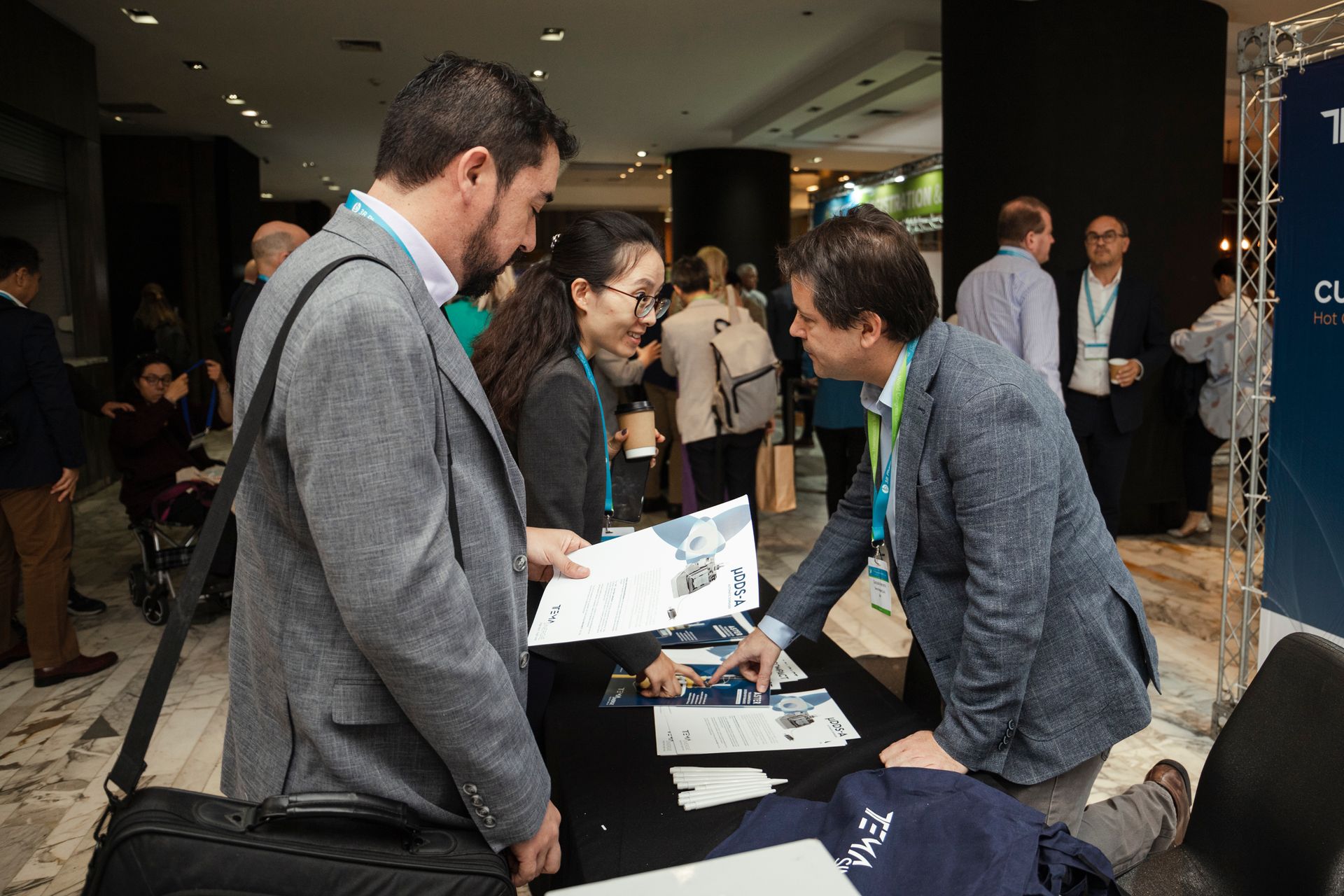 Menschen bei einem Aussteller in Industrieausstellung beim Theranostics World Congress 2024 in Santiago, Chile