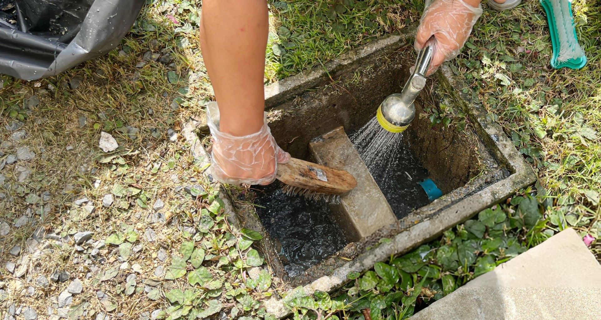 An unrecognized person is providing commercial grease trap cleaning services with a wire brush. An unrecognized person is providing commercial grease trap cleaning services with a wire brush.