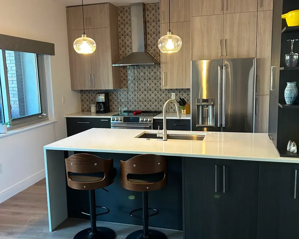 Modern kitchen with a white countertop island, wooden cabinets, stainless steel appliances, and two bar stools.