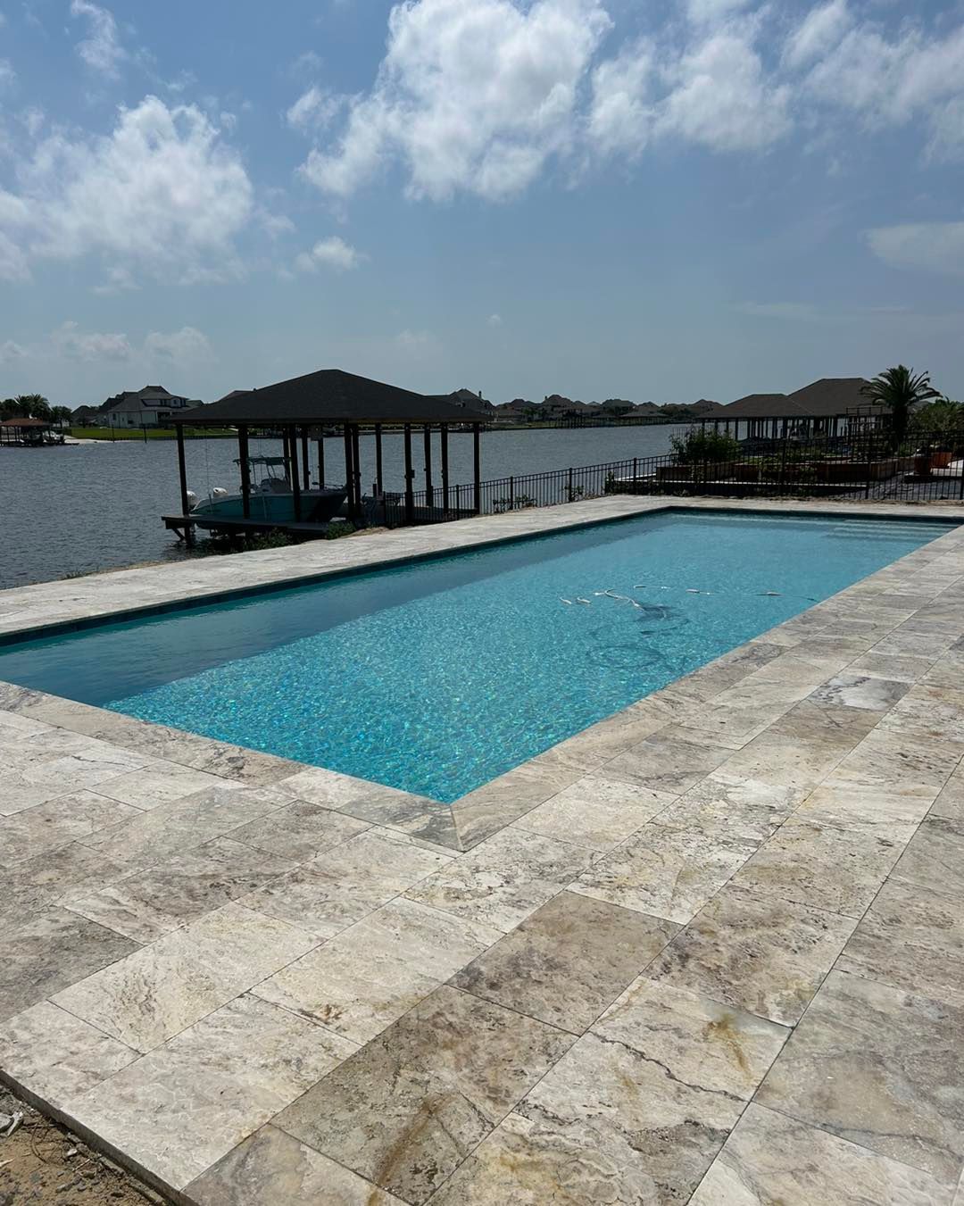 A large swimming pool with a dock in the background