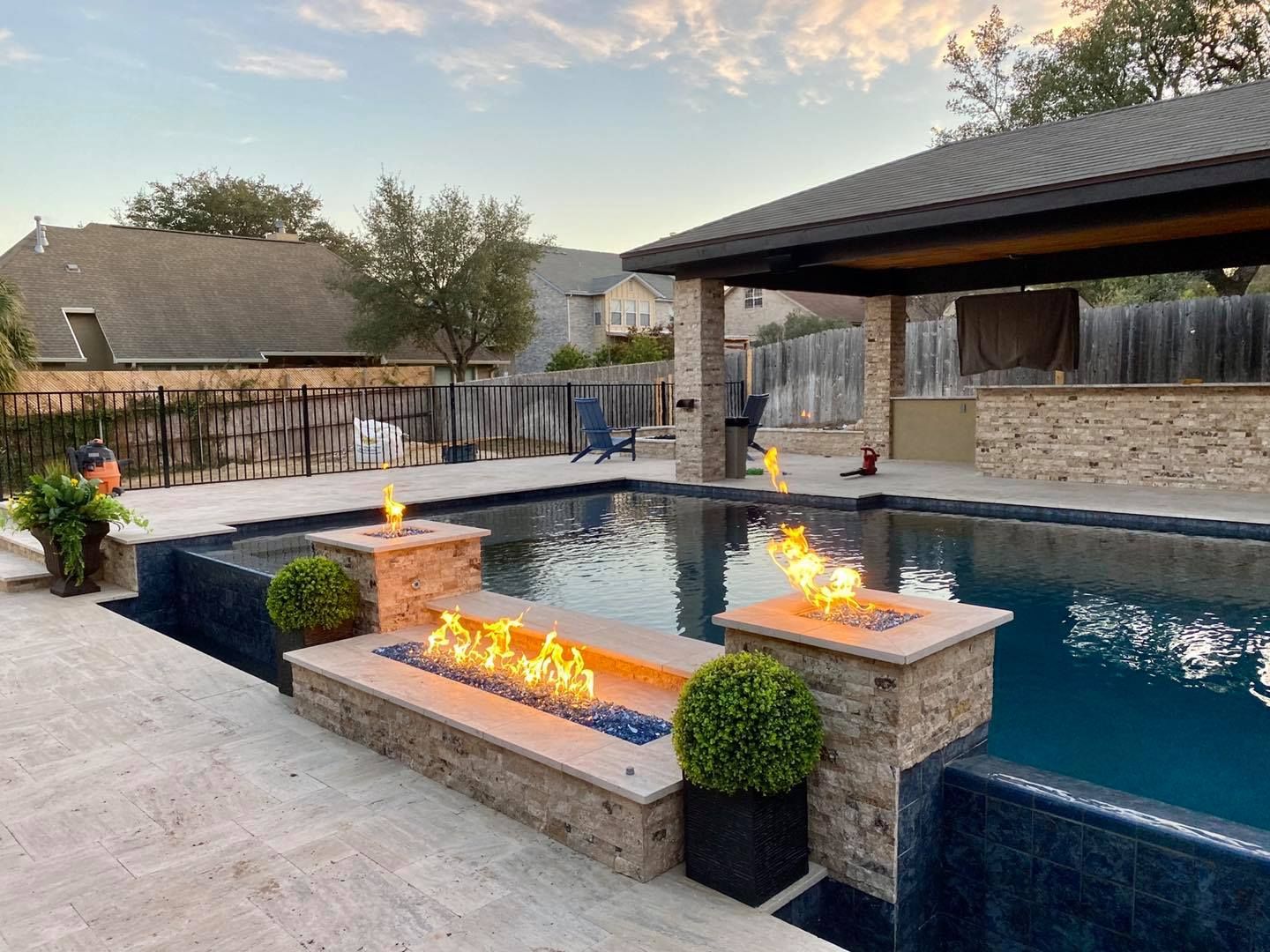 A large swimming pool with a fire pit in the middle of it.