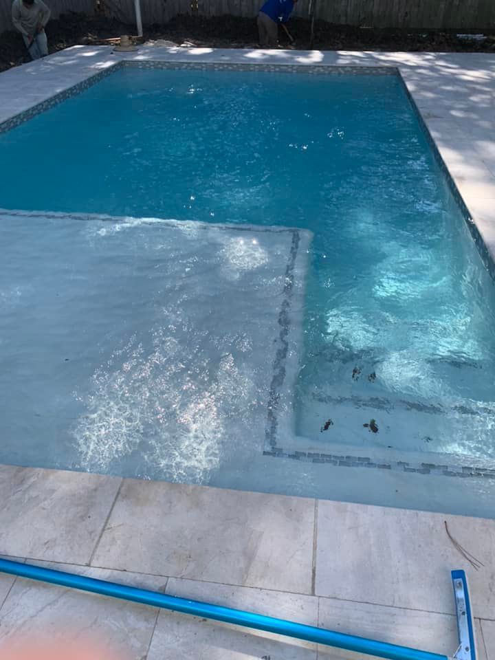 A large swimming pool is being built in a backyard.