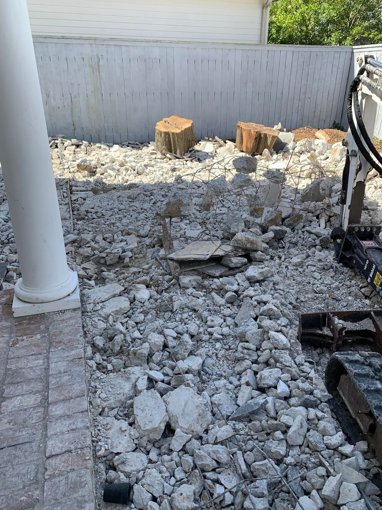 A pile of rocks is sitting on the ground in front of a house.