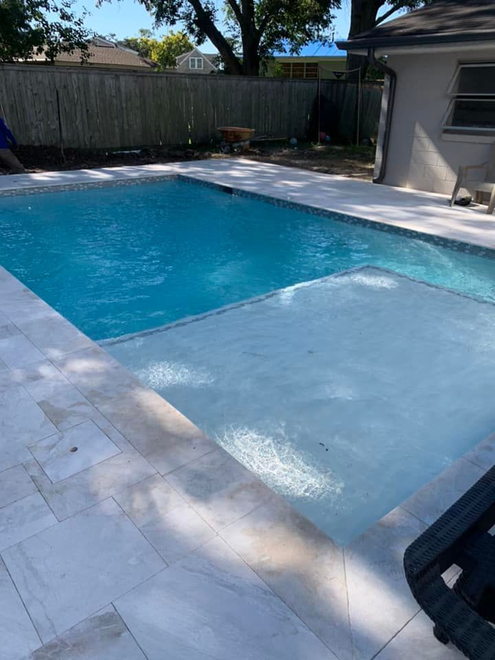 There is a large swimming pool in the backyard of a house.