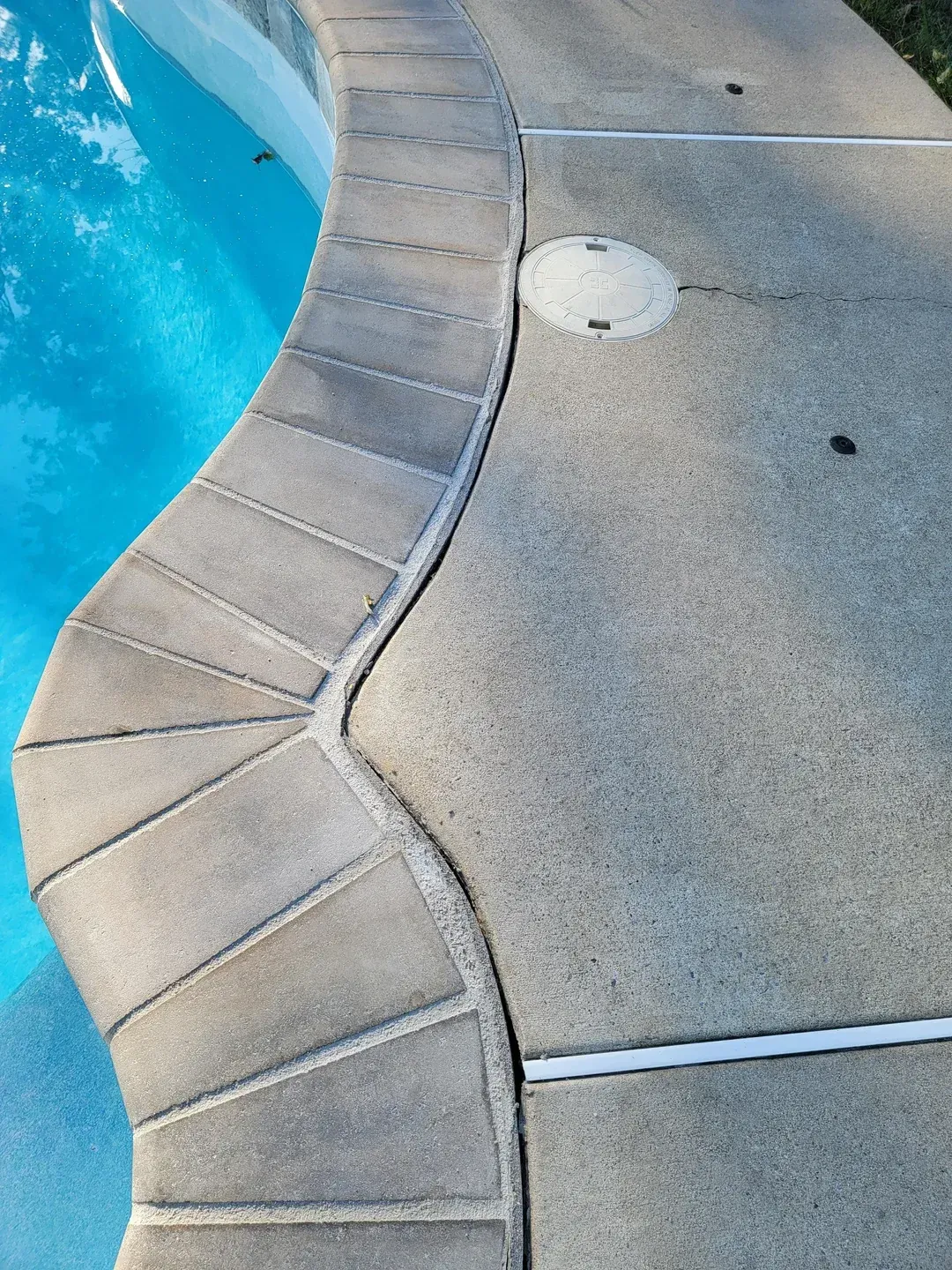 A man in a red shirt is working on a swimming pool.