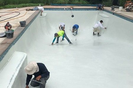 A group of people are working on a swimming pool.