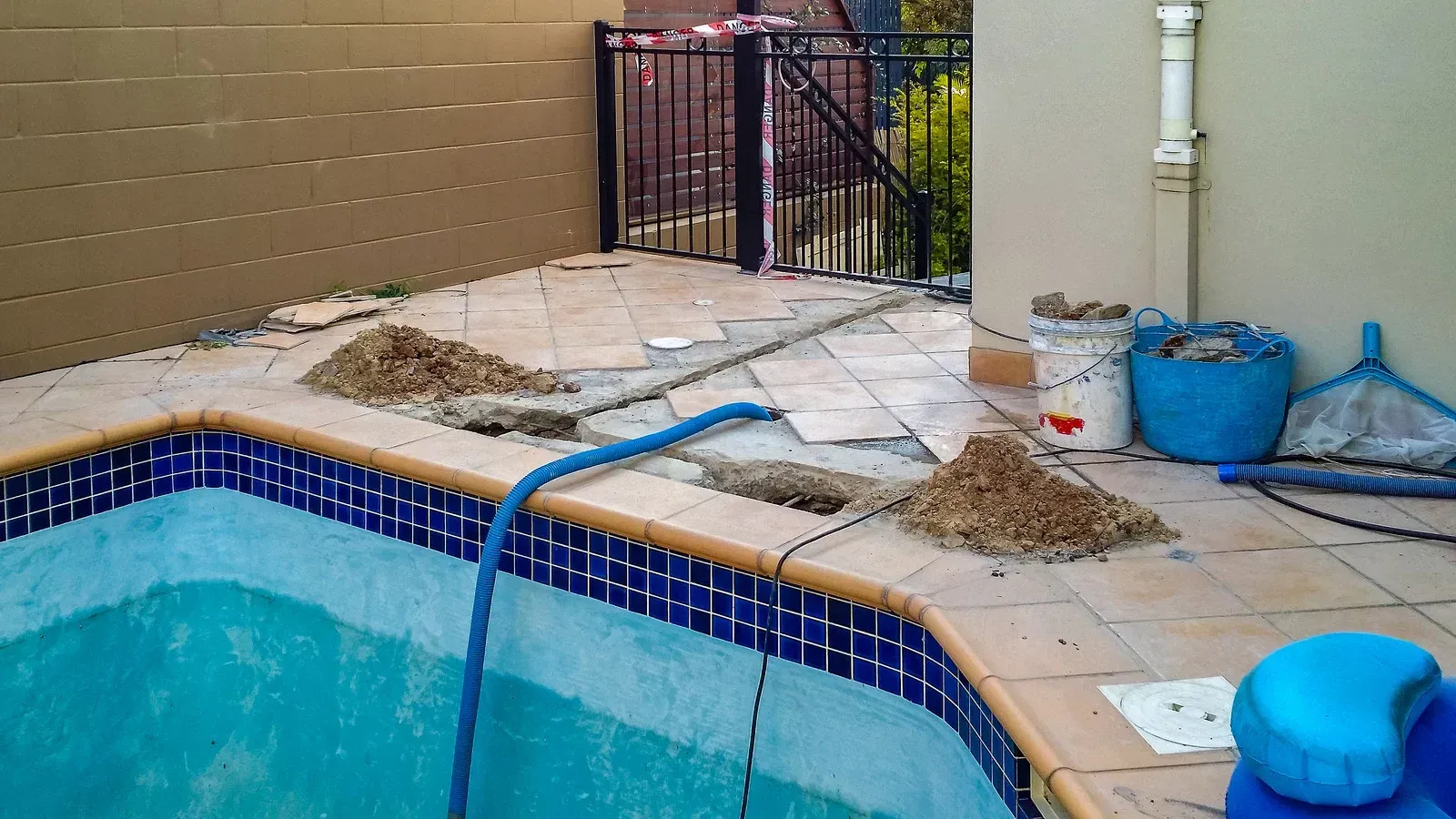 A swimming pool with a blue hose attached to it