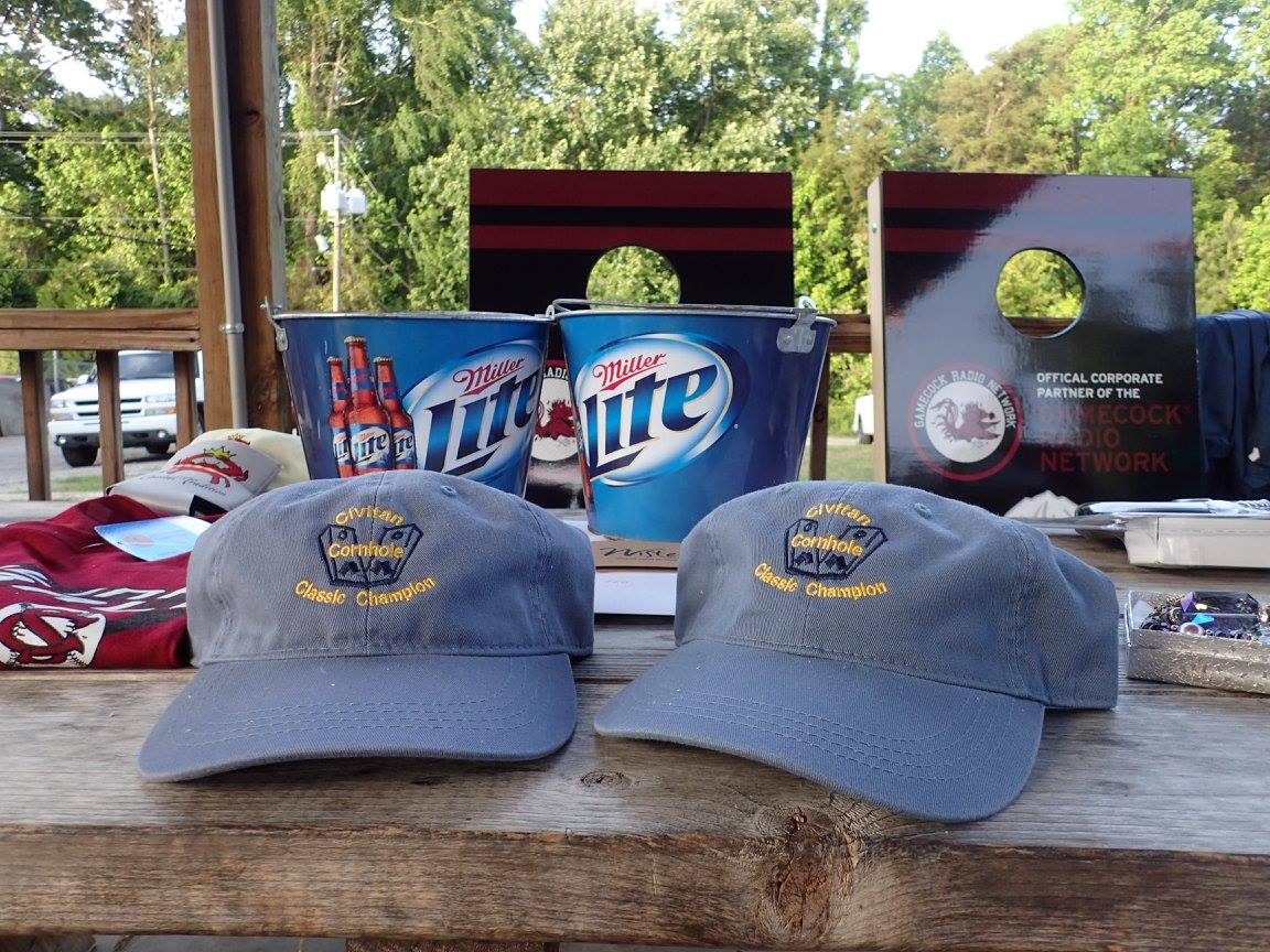 Two miller lite hats are sitting on a wooden table