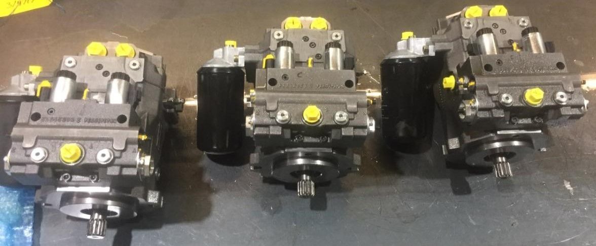 three hydraulic pumps are lined up on a table