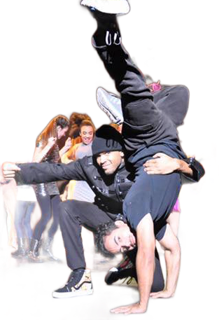 Two male dancers performing a handstand with one supporting the other's feet; stage with dancers in background.
