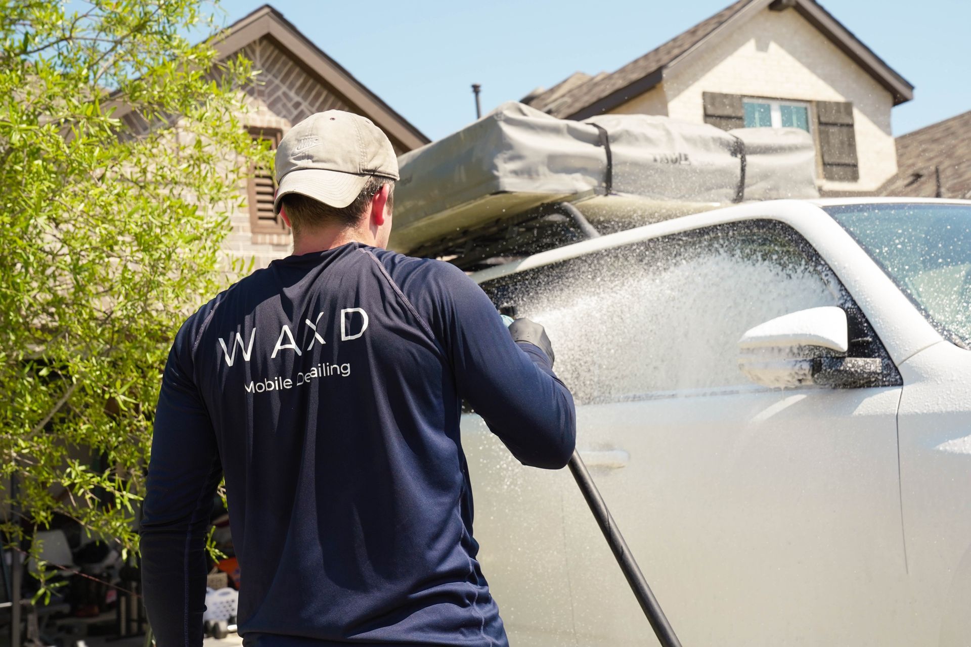 A man is standing next to a white suv on a sidewalk.