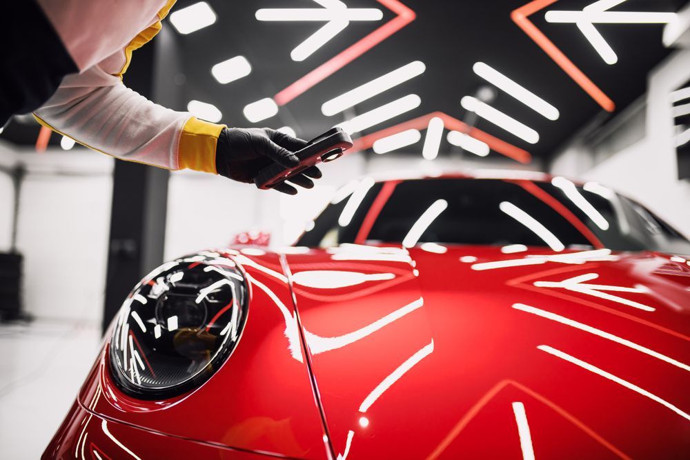 Person in Black Gloves Measuring the Glossy Red Hood of a Car — TrueGloss Elite Coatings In Wyong, NSW