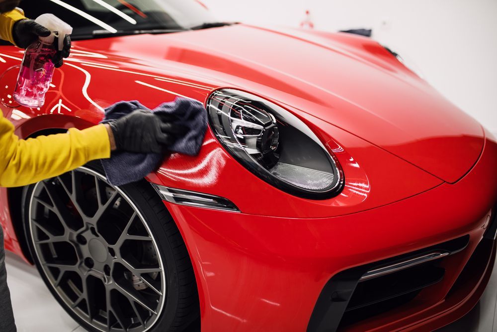 Cleaning the red hood of a sports car with a cloth — TrueGloss Elite Coatings In Wyong, NSW