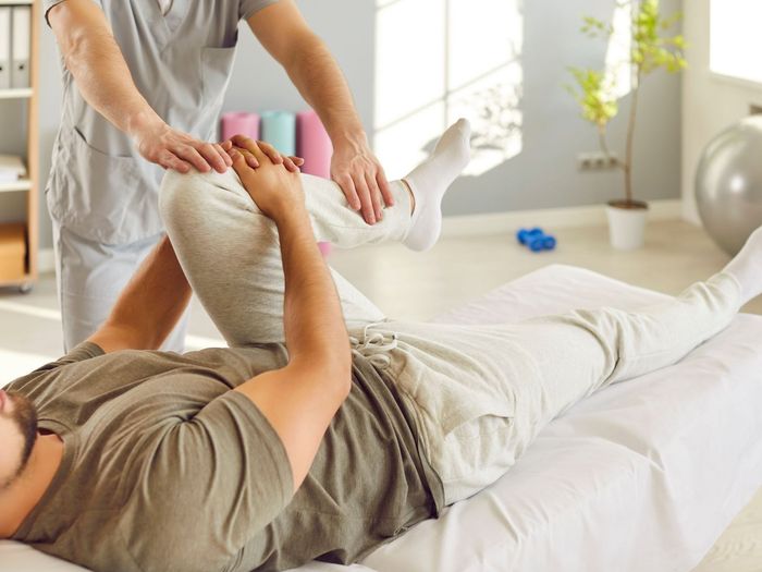 Chiropractor assisting a patient with stretching