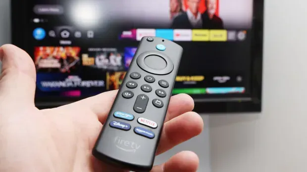 A person is holding a remote control in front of a television. MyStreamVision