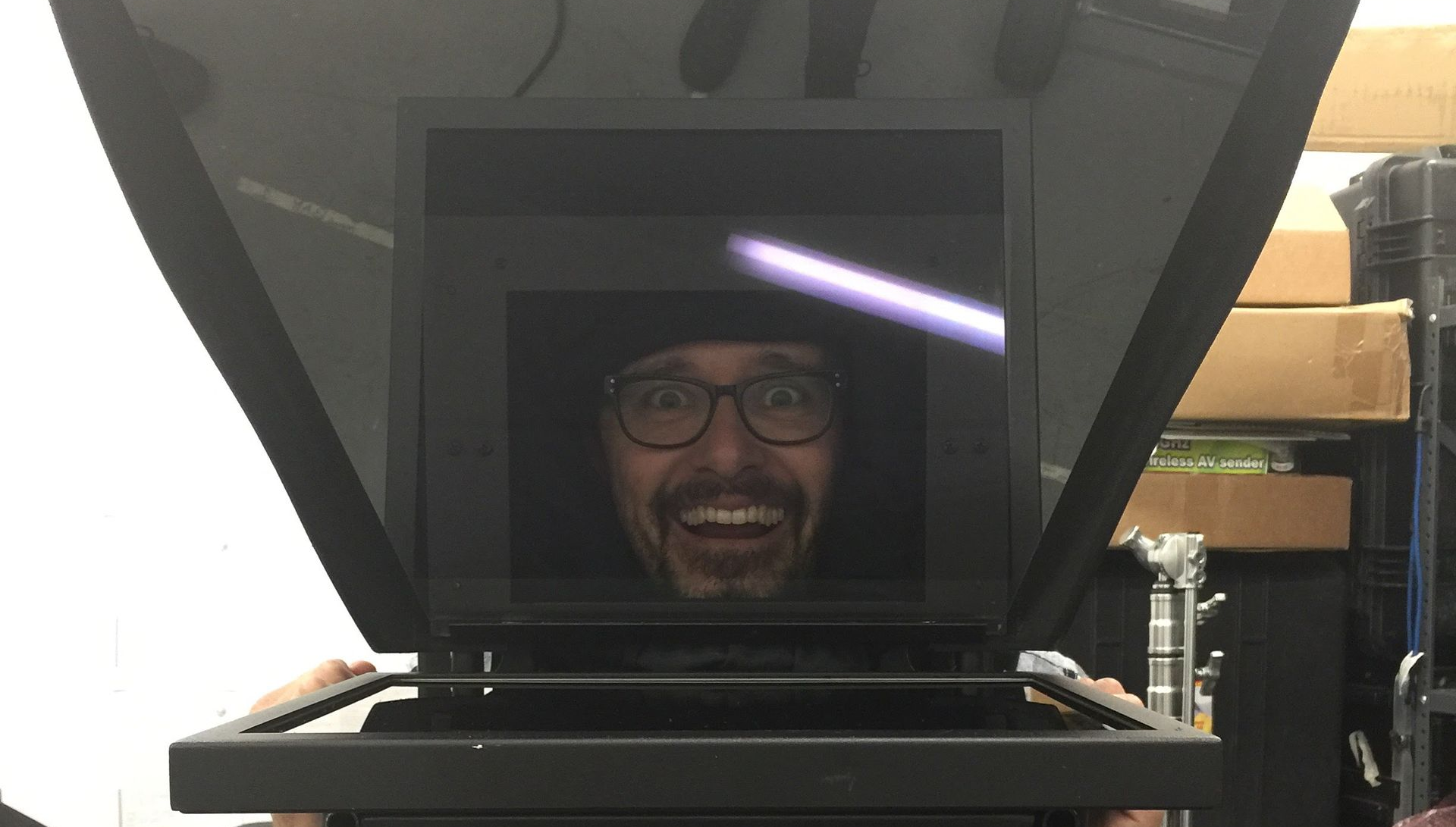 Dave looking up through a teleprompter display, appearing to interact with a light beam.