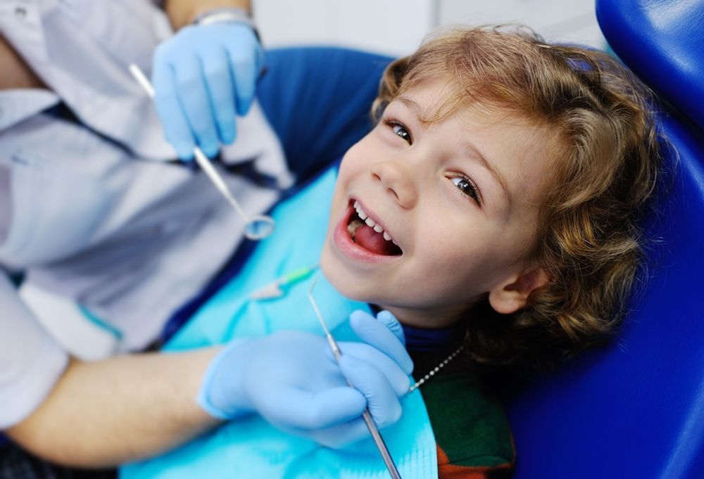 A Little Boy is Sitting in a Dental Chair — Tweed Banora Dental In Tweed Heads South, NSW