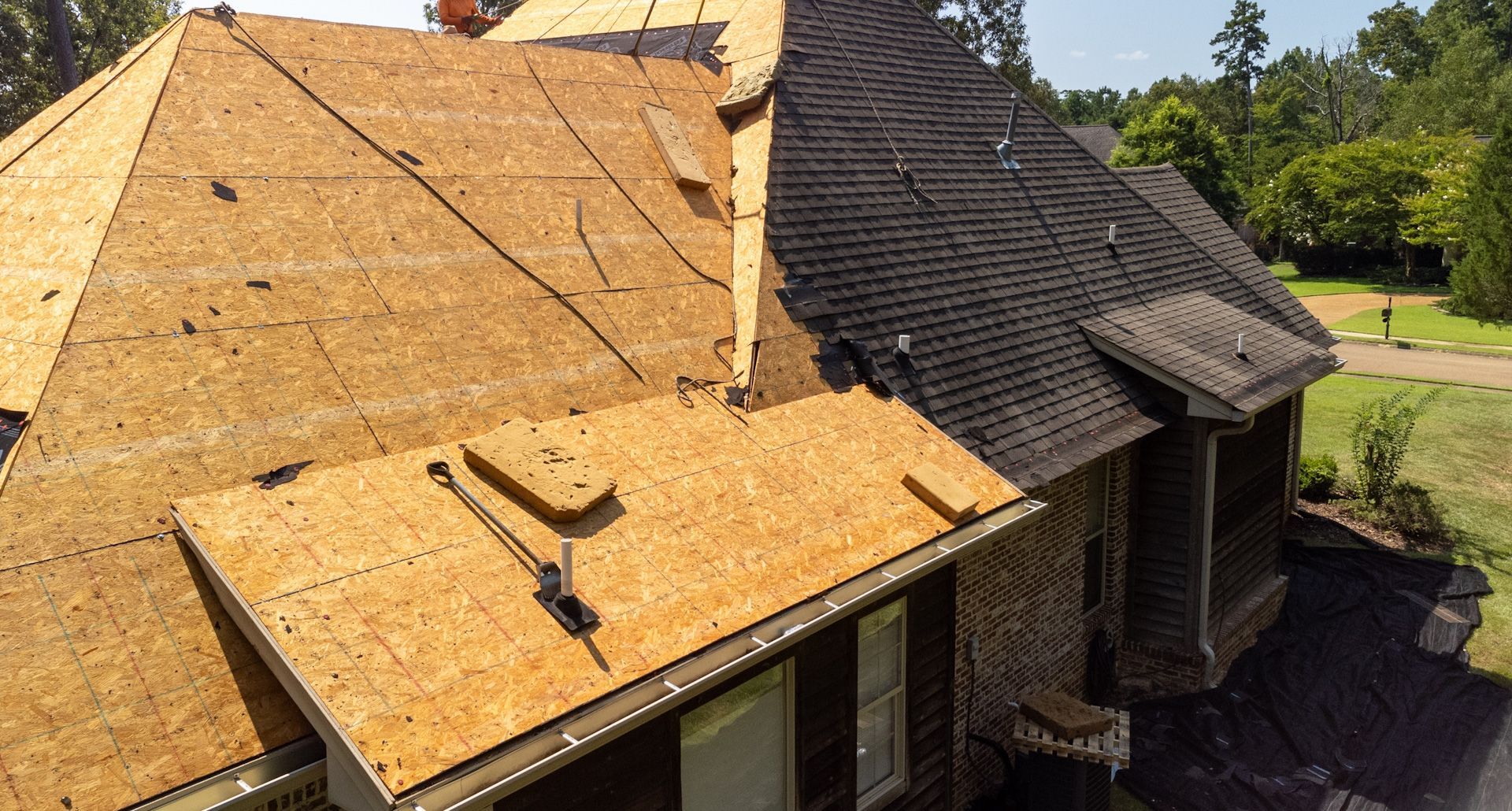 An aerial view of a house with a roof that is being repaired.