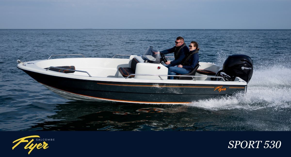 Boat on water with person steering, lighthouse in the background.