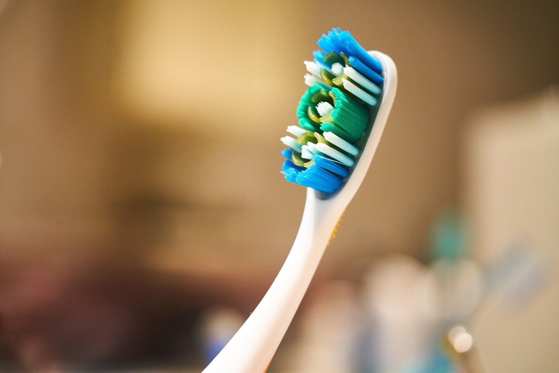 A close up of a toothbrush with blue and white bristles