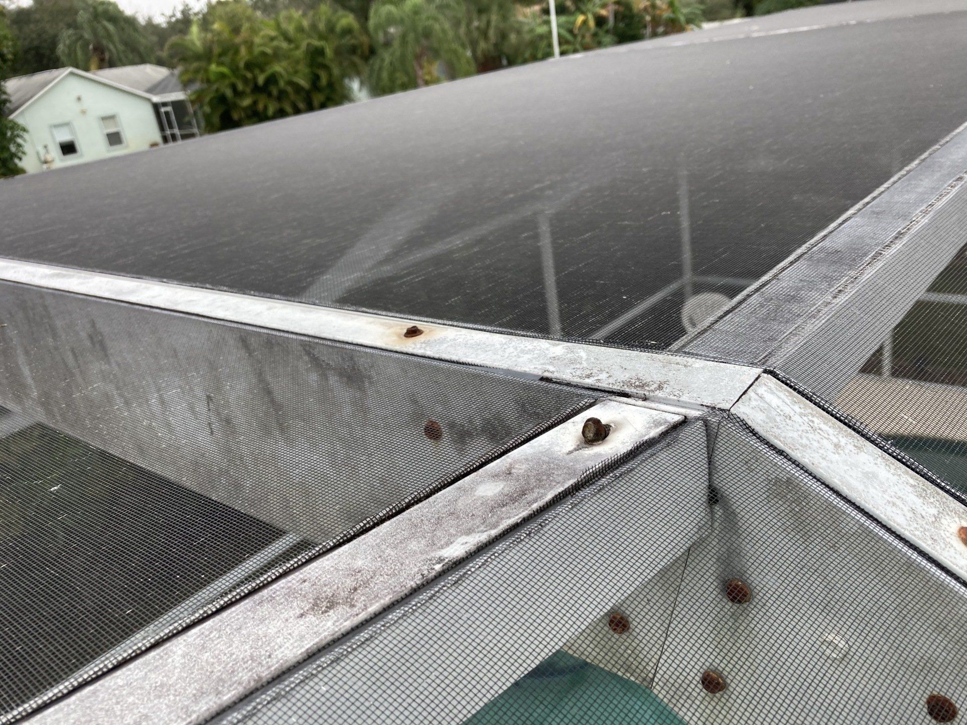 A close up of a metal structure with a roof in the background.