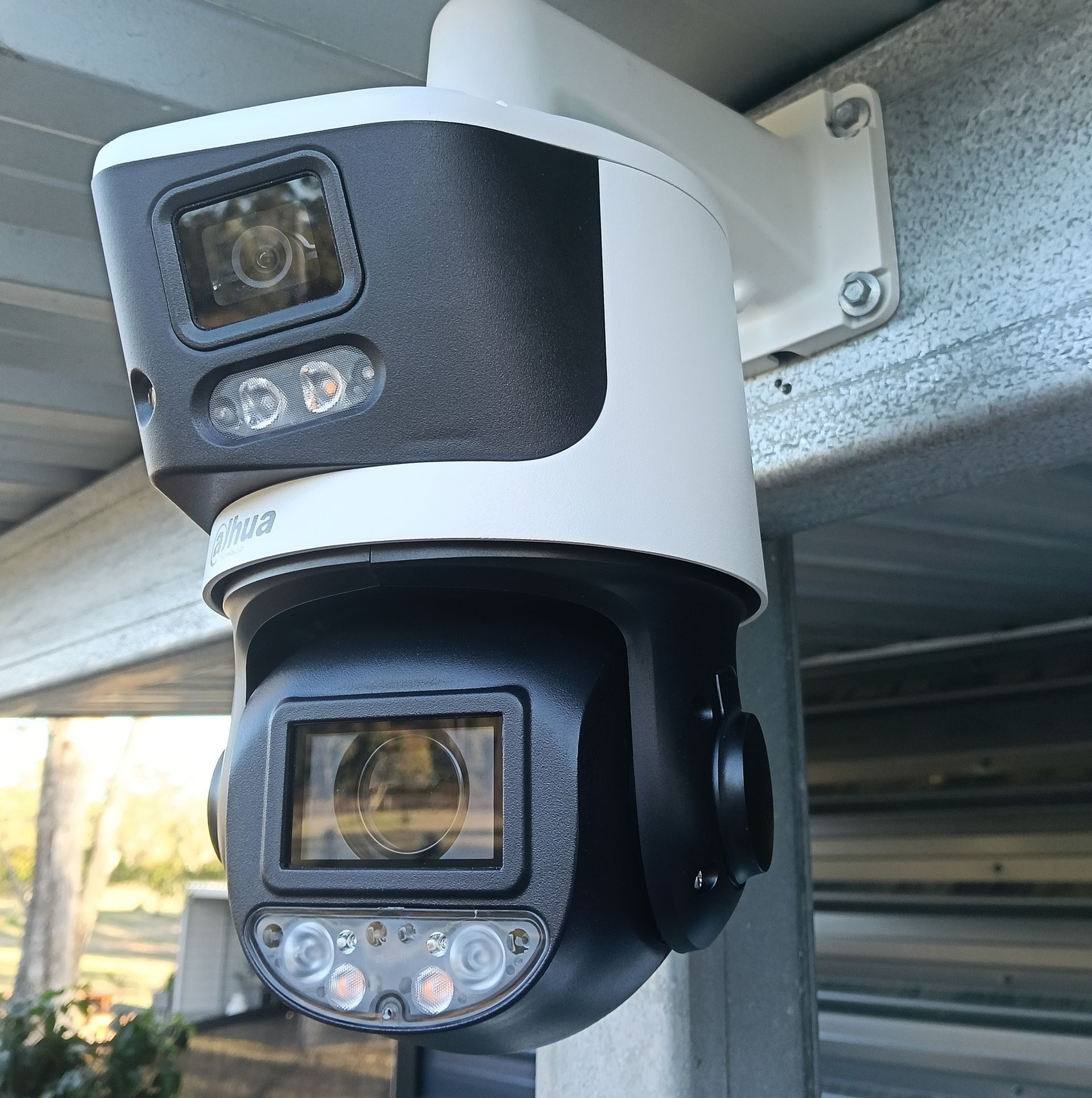 Person Installing a White Security Camera — Coastline Installations In Emu Park, QLD