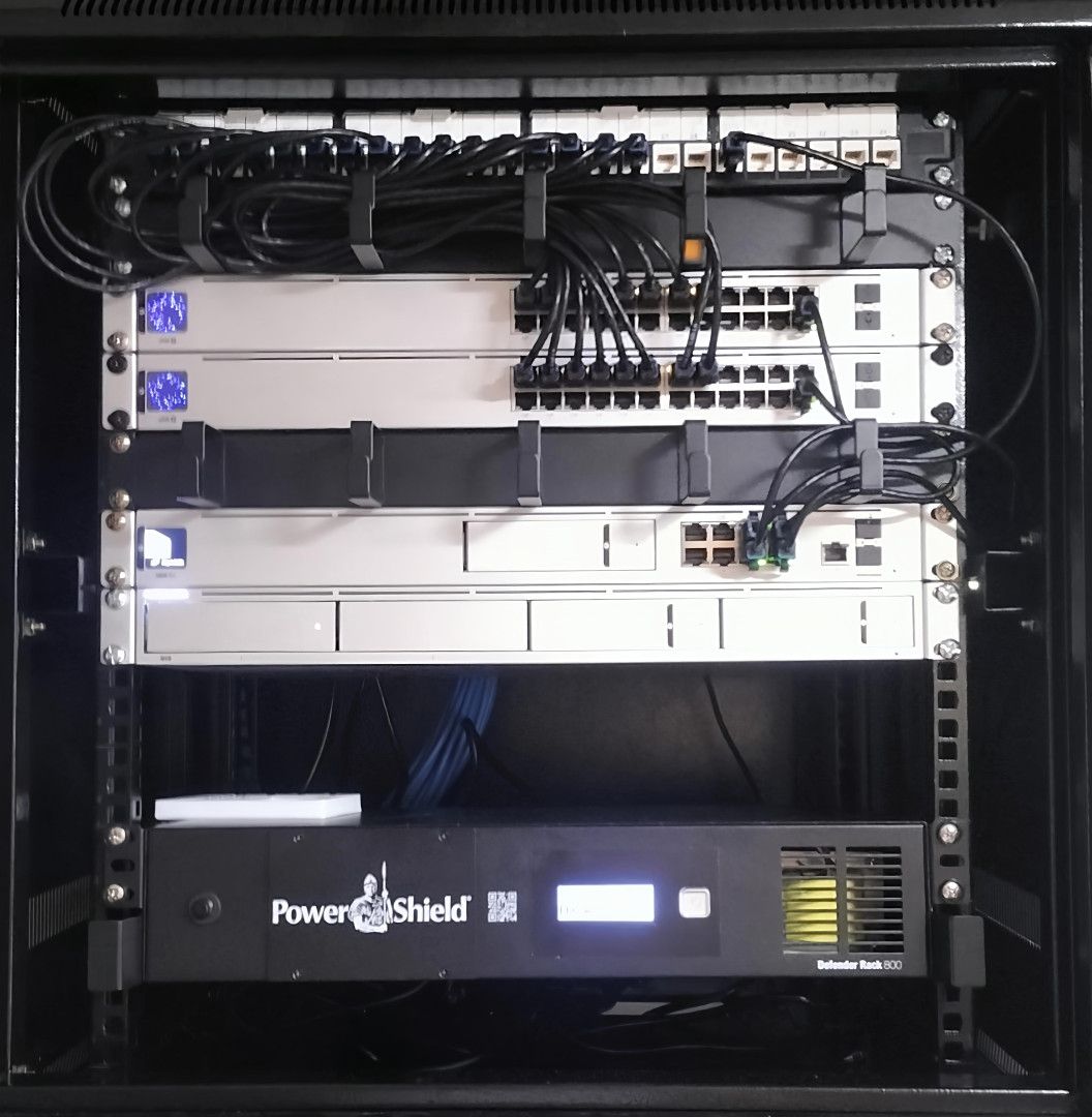 Network server rack with multiple switches, patch panels, and a UPS unit.