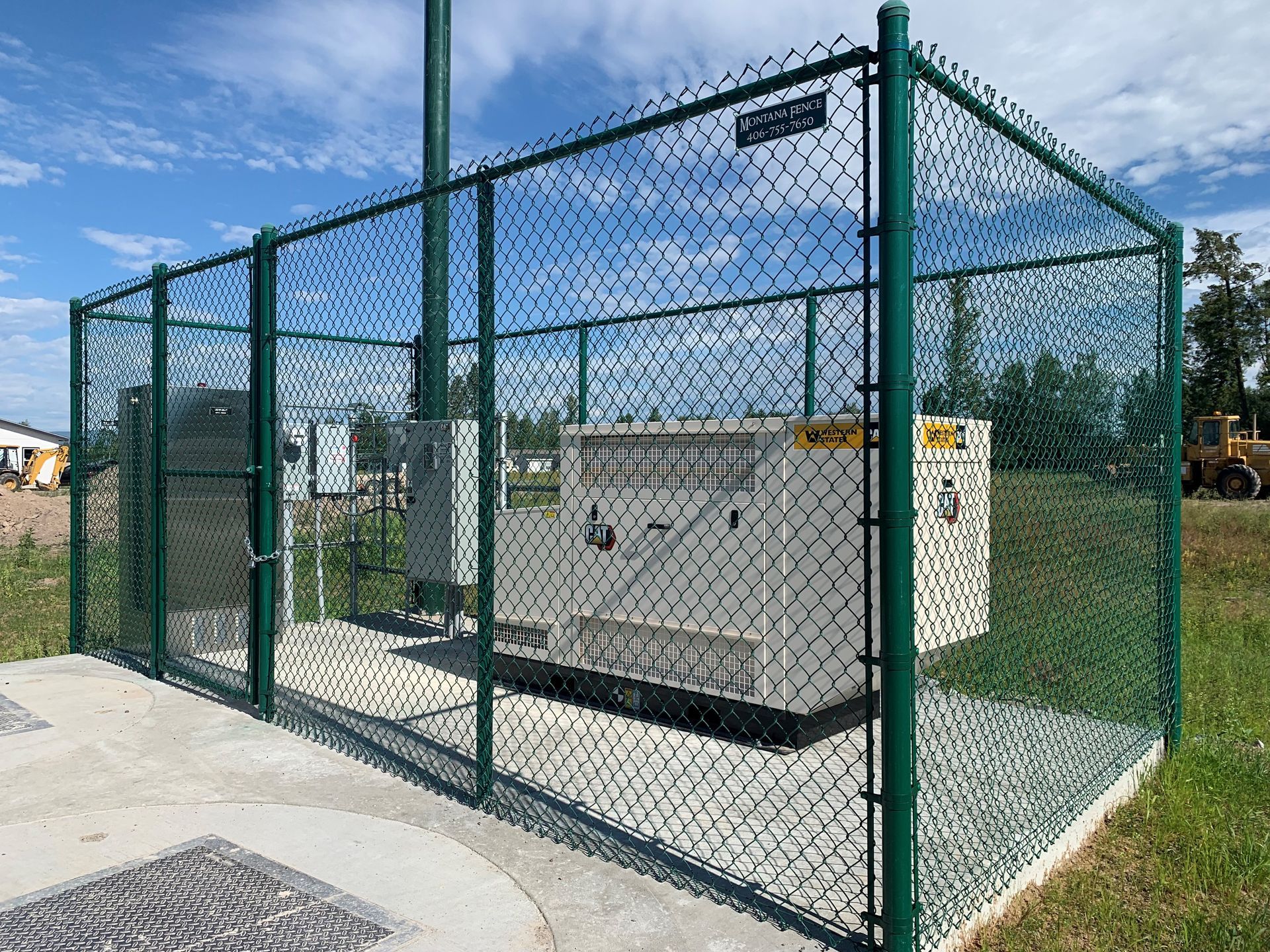 A generator is behind a chain link fence.