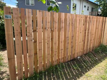 A wooden fence is sitting in front of a house.