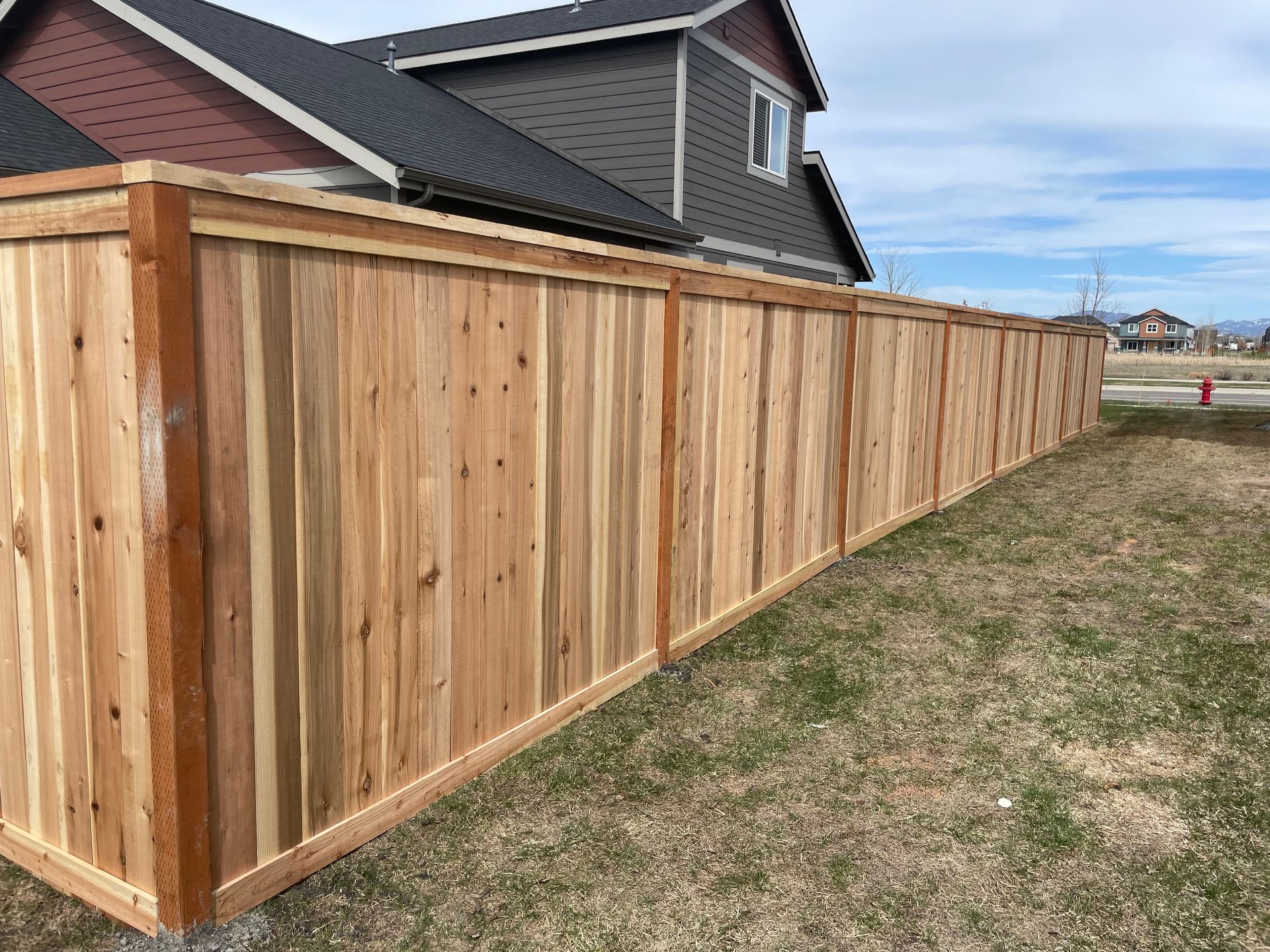 A wooden fence is sitting in front of a house.